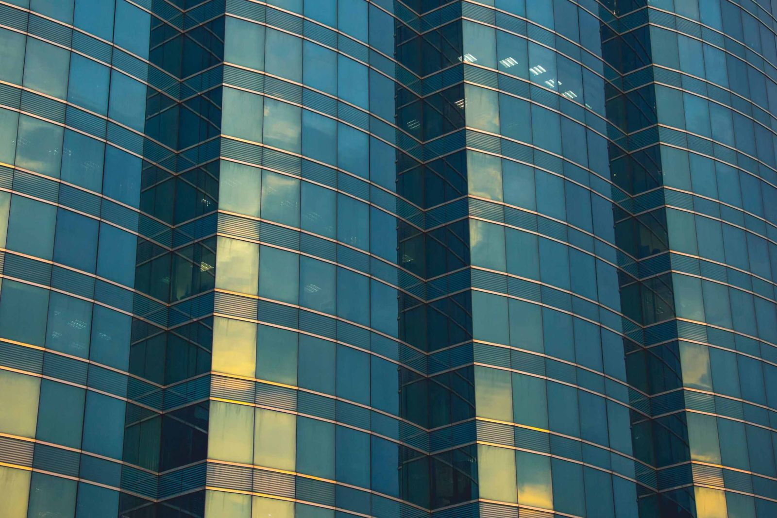 Façade d'un immeuble moderne en verre avec reflets, illustrant le nettoyage et l’entretien de bâtiments à Genève.